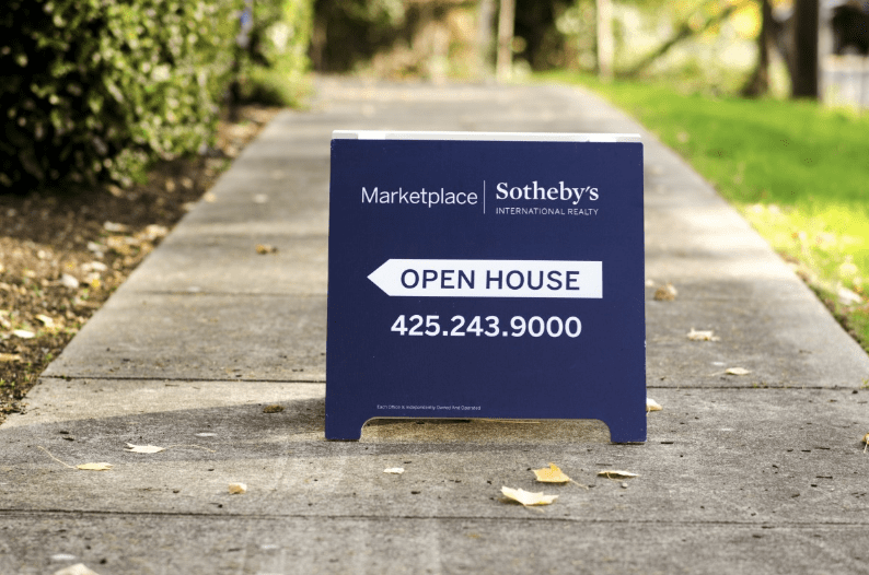 A real estate for sale sign advertising an open house